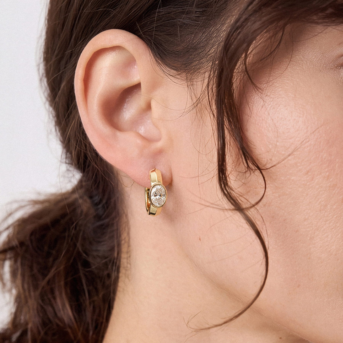 Oval Bezel-Set Lab-Grown Diamond Huggie Hoop Earrings worn for styling | MET-RE-0024-M04
