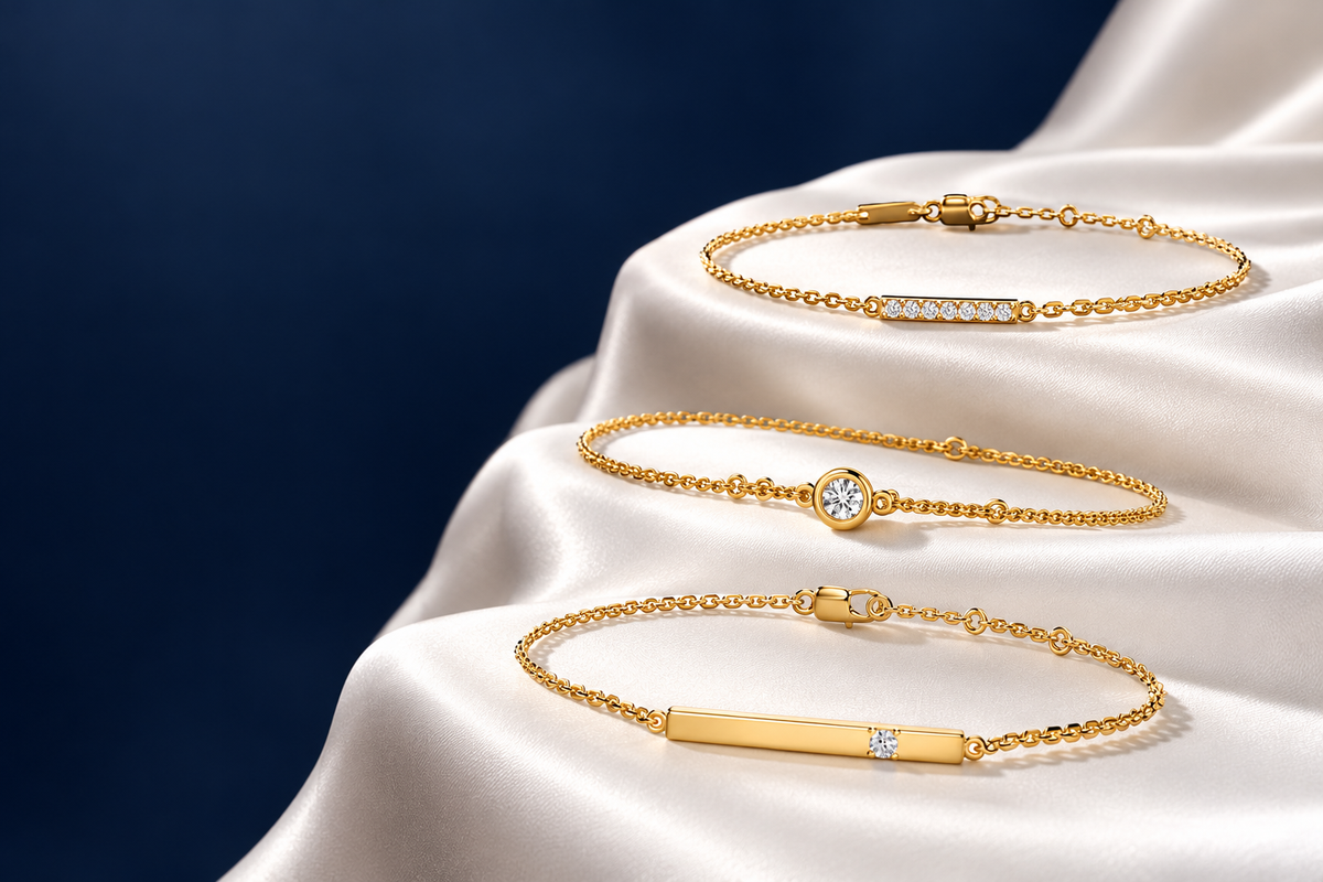 Three MET DIAMOND gold bracelets on white satin against a navy background