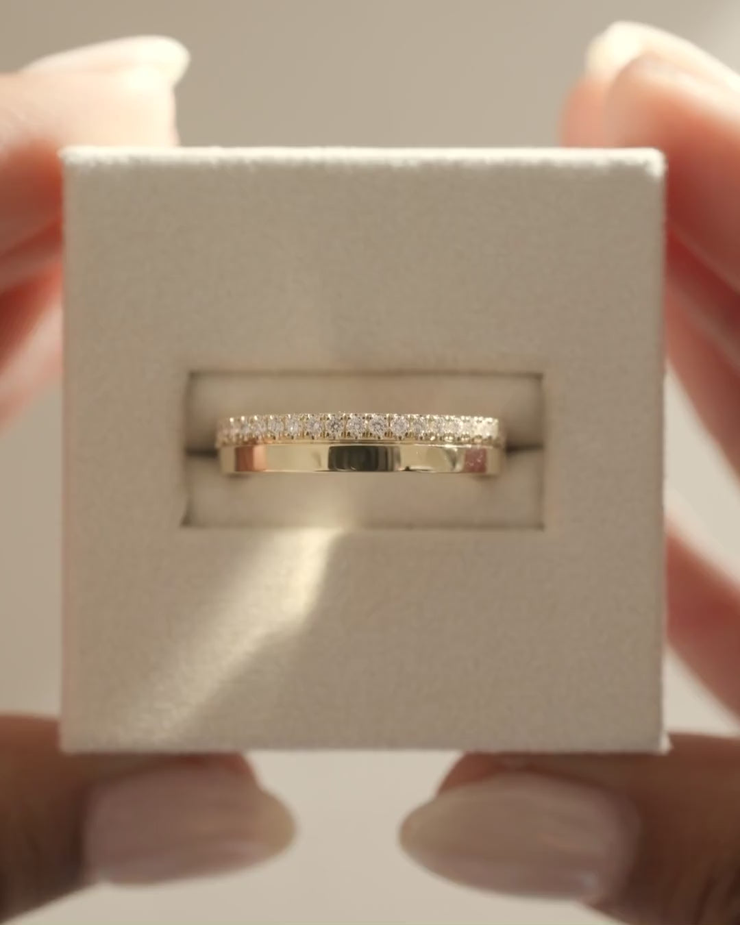 MET 0381 yellow-gold edge-pavé cigar band shown alone on a hand-held display cushion.